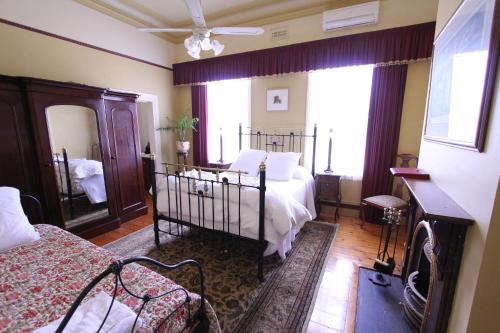 a bedroom with a bed and a large window at Palm House in Maldon