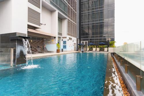 a swimming pool with a fountain in the middle of a building at Four Points by Sheraton Bangkok Ploenchit Sukhumvit in Bangkok