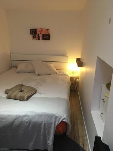a bed in a bedroom with a person sitting on it at Chambre double 30km de la Tour Eiffel in Saint-Michel-sur-Orge