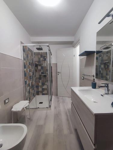 a white bathroom with a sink and a shower at Yellow Dream B&B 2 in Torre Melissa
