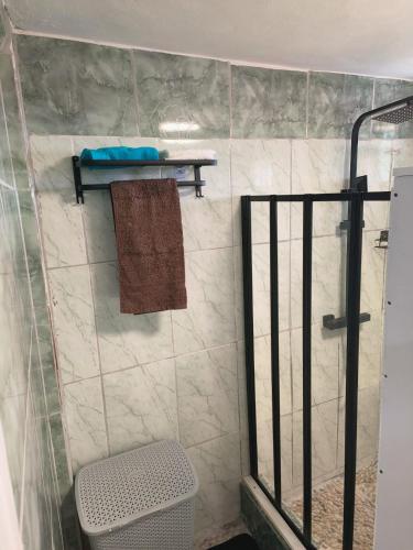 a bathroom with a shower and a towel on a wall at Ocean View Guest Apt in Kingstown