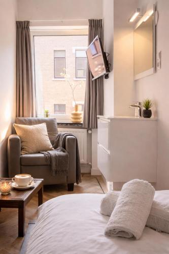 a living room with a bed and a couch and a sink at Budget-Friendly Room Tilburg Center Prime Loc in Tilburg