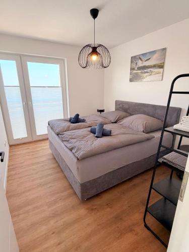 a bedroom with a large bed in a room with windows at Maritime Suite an der Geeste in Bremerhaven
