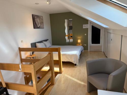 a bedroom with a bed and a chair in a room at Duplex vernieuwd appartement Dujardin bubbelbad in Blankenberge