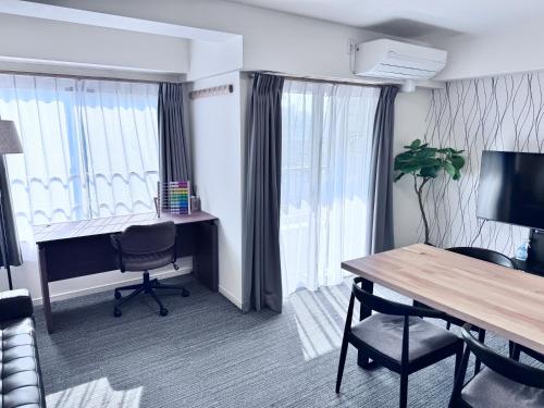 a hotel room with a desk and a table and chairs at ITO House-伊藤家 in Tokyo
