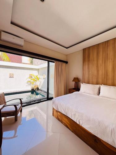 a bedroom with a large bed and a large window at Villa Reisya in Nusa Dua