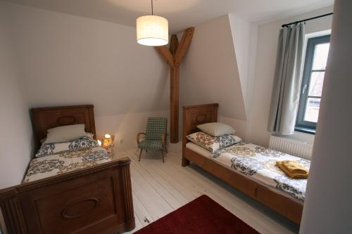 a room with two beds and a chair in it at Vila Krocinka in Prague