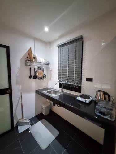 a small kitchen with a sink and a window at Nua Tone Riverside in Thalang