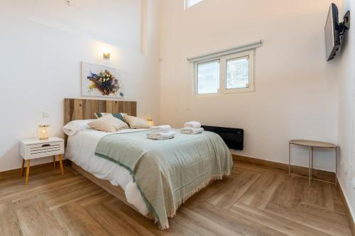 a bedroom with a large bed and a window at El loft del sardi in Santander
