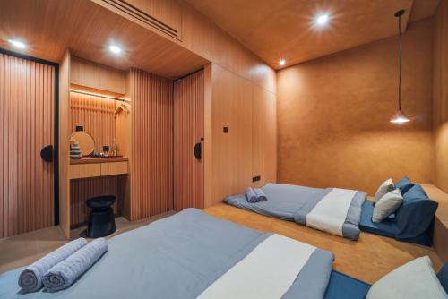 two beds in a room with wooden walls at Redbrick Villa By The Feelas in Bandung