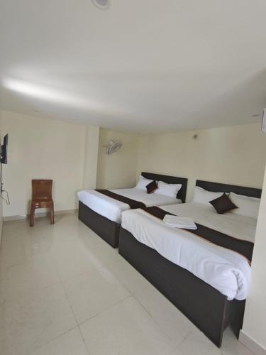 two beds in a hotel room with at HOTEL VAJRA Grand in Tirupati