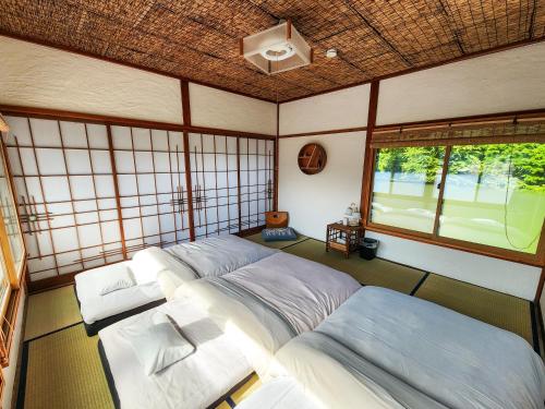 a room with two beds and a window at Guesthouse Mikansei in Kawanehon