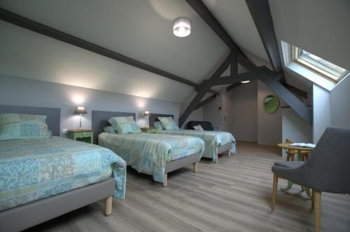 a attic bedroom with two beds and a window at Le jardin sainte anne in Balnot-sur-Laignes