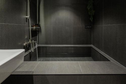 a bathroom with a sink and a bath tub at Anook Ryokan Hotel Daejeon Daeheung in Daejeon