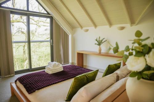 a large room with a bed with a large window at Oak Lodge in Knighton