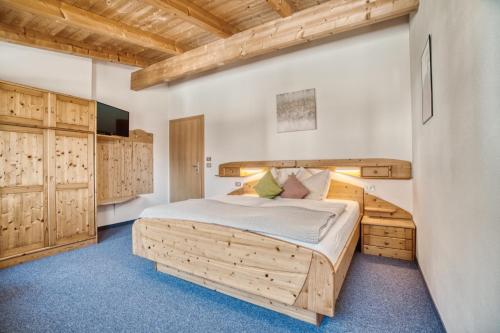 a bedroom with a wooden bed and wooden cabinets at byRosi Apartments in Parcines