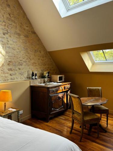 a kitchen with a sink and a table in a room at La maison des romans du Château du Sollier - Charme Calme Confort Climatisation - à 5mn du péage de Bourges à la campagne - stationnement privé -Panette Collection in Bourges