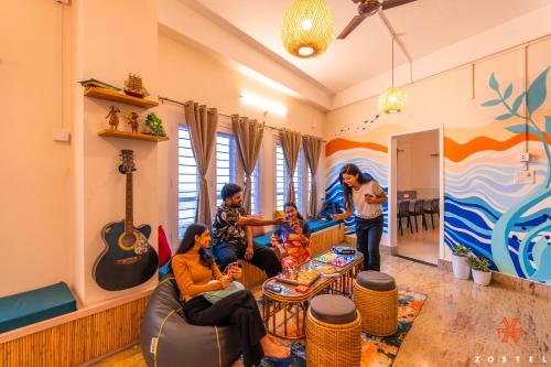a group of people in a living room with instruments at Zostel Guwahati in Guwahati