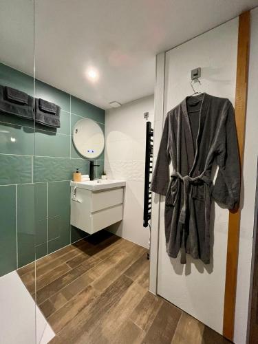 a bathroom with a robe hanging on a door at Appartement confortable et accessible in Pelves