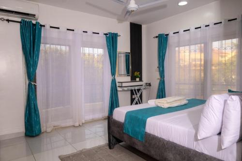 a bedroom with a bed with blue drapes at C Waves Palm Terraces in Mombasa