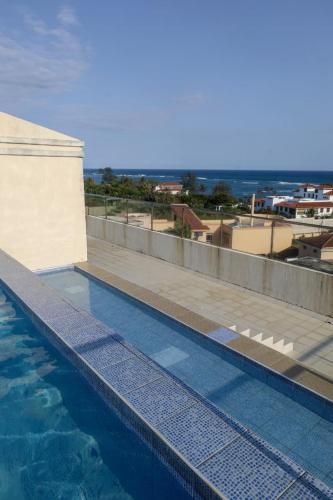 a swimming pool with a view of the ocean at C Waves Palm Terraces in Mombasa