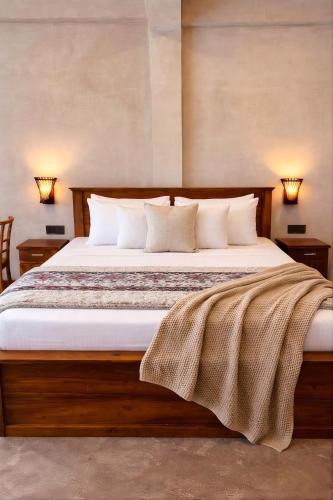 a bedroom with a large bed with white sheets and pillows at Viora Lodge in Nuwara Eliya