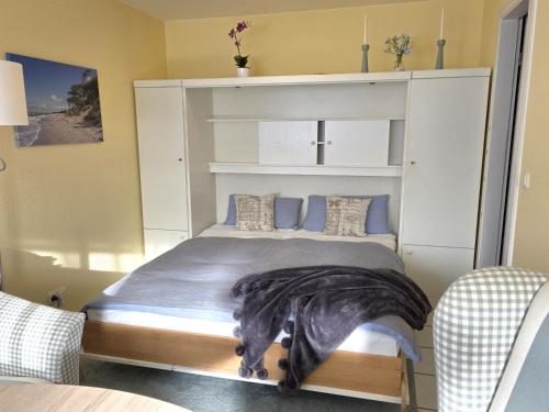 a bedroom with a large white bed with blue pillows at Stettiner Str 6c in Grömitz