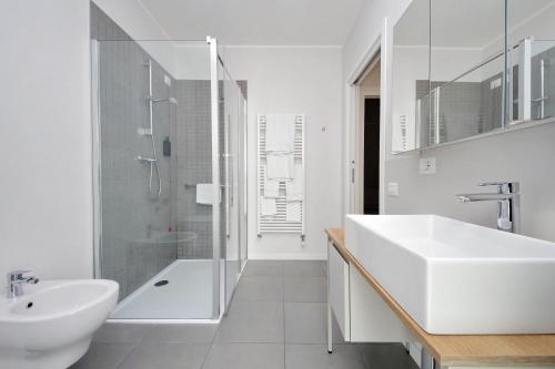 a white bathroom with a sink and a shower at Quarto Verde in Bergamo