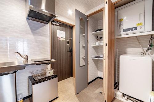 a small kitchen with a refrigerator and a sink at New open! Hopetree 京都 in Kyoto
