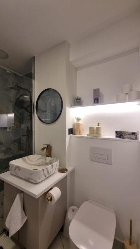 a white bathroom with a sink and a toilet at Solovan Hill in Sighetu Marmaţiei