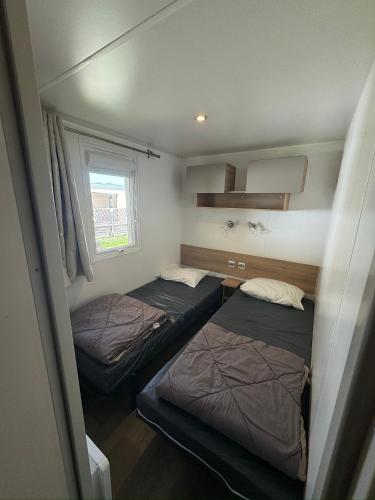 a bedroom with two beds and a window at Camping le Neptune in Argelès-sur-Mer
