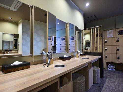 a large bathroom with two sinks and mirrors at Dormy Inn Hakata Gion in Fukuoka