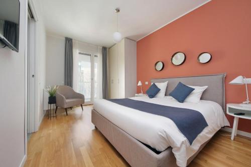 a bedroom with a large bed with an orange wall at Quarto Verde in Bergamo