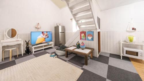 a living room with a tv and a checkered floor at Gapyeong Jmong Choncance&Camping Pension in Gapyeong