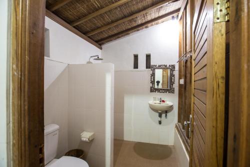 a bathroom with a toilet and a sink at Villa Mandi Resort & spa in Ubud