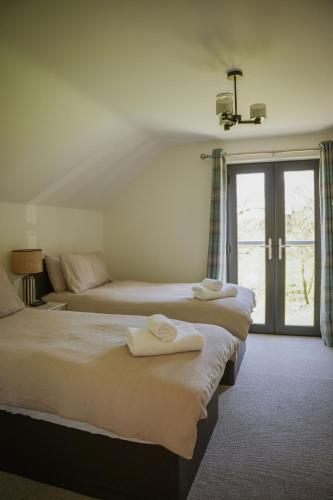 a hotel room with three beds and a window at Oak Lodge in Knighton