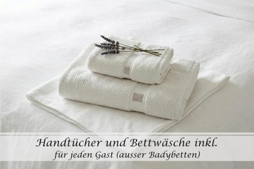 a couple of towels sitting on top of a bed at Ferienwohnung Feinheit - Gulfhof nahe Greetsiel mit Sauna, Garten & 3 Schlafzimmern in Krummhörn