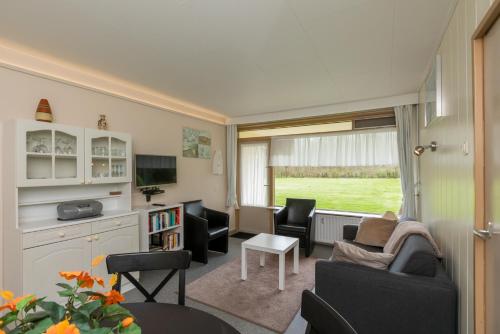 a living room with a couch and chairs and a table at Welcome in - Appartement dichtbij het strand, met fietsenberging en ruim terras in Vlissingen