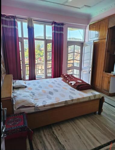 a bedroom with a bed with windows and a balcony at Harmony Homestay Couple & Family friendly prime location Easy access to Mall Rd -City view in Solan