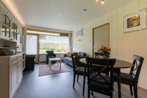 a kitchen and a living room with a table and chairs at Welcome in - Appartement dichtbij het strand, met fietsenberging en ruim terras in Vlissingen