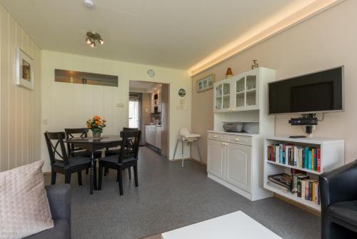 a living room with a table and a dining room at Welcome in - Appartement dichtbij het strand, met fietsenberging en ruim terras in Vlissingen