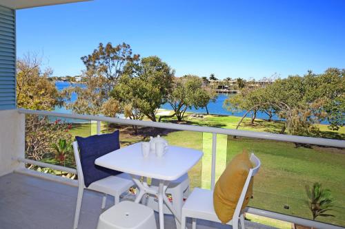a balcony with a table and chairs and a view of the water at Portsea in Mooloolaba