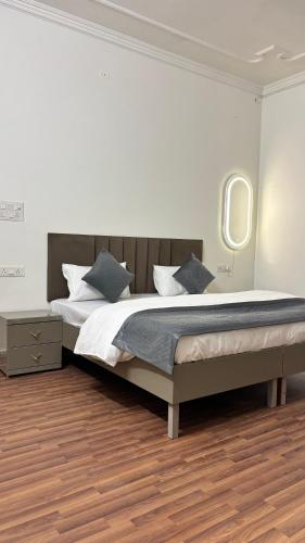 a bedroom with a large bed and a wooden floor at Hotel Divine in Faridabad