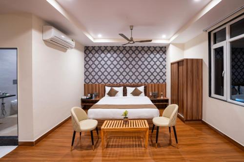 a bedroom with a bed and a table and chairs at The Parmatma Hotel in Udaipur