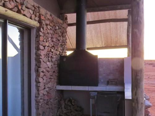 a kitchen with a stone wall with a stove at Tented Camp in Augrabies in Kakamas