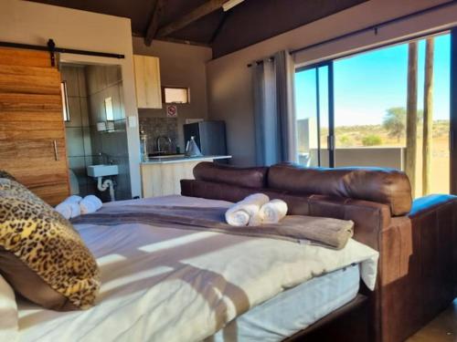 a bedroom with a large bed with a leather couch at Tented Camp in Augrabies in Kakamas