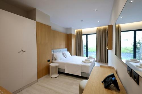 a bedroom with a bed and a desk and a sink at Hotel Tutti in Durrës