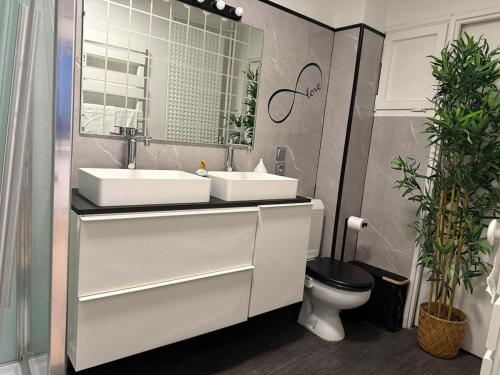 a bathroom with two sinks and a toilet at Altitude 24 Panorama and Spa in Mulhouse