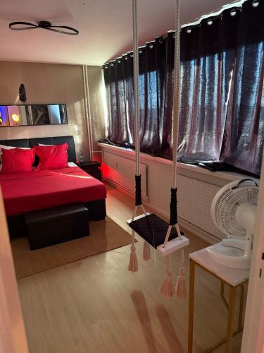 a bedroom with a red bed and two swings at Altitude 24 Panorama and Spa in Mulhouse