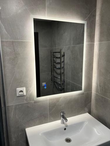 a bathroom with a sink and a mirror at Ludza Comfort Apartment in Ludza